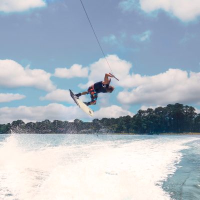 a man flying through the air while riding a wave in the ocean